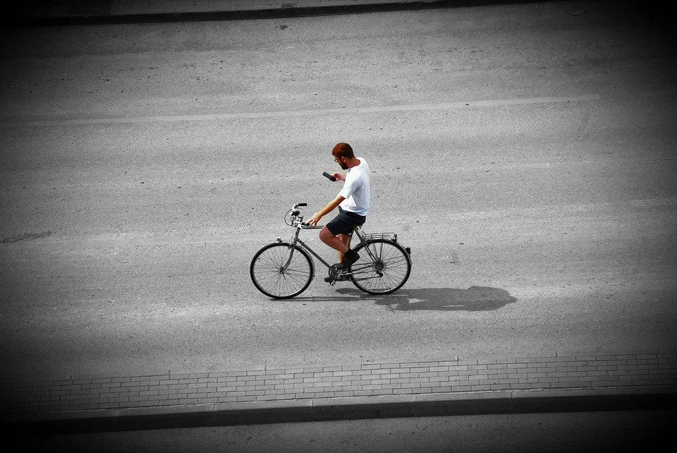 jeune homme à vélo sur son téléphone