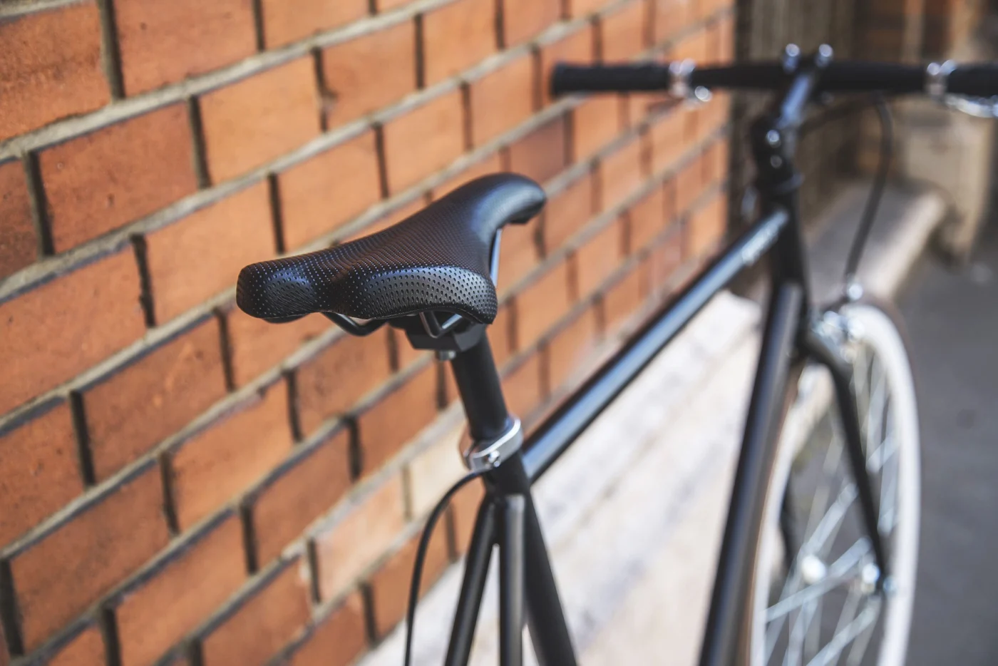 vélo singlespeed noir sur mur en brique