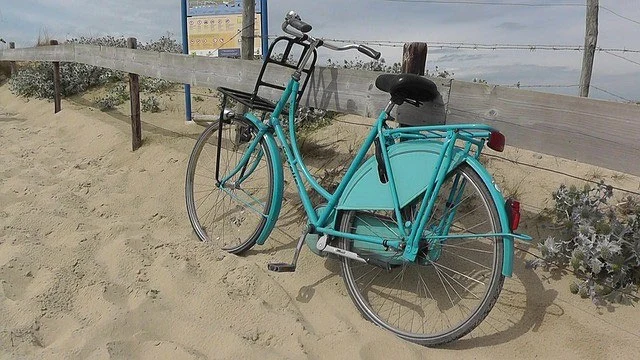 vélo hollandais bleu vert sur la plage