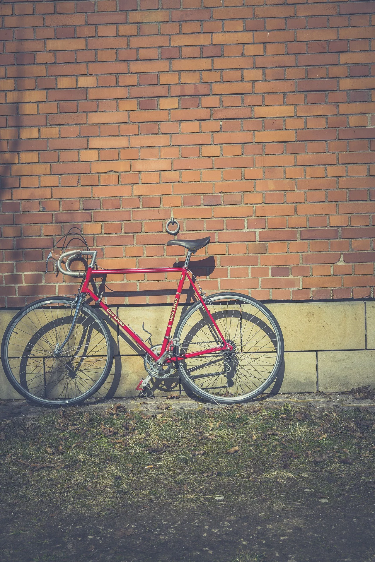 vélo de course rouge sur mur en brique