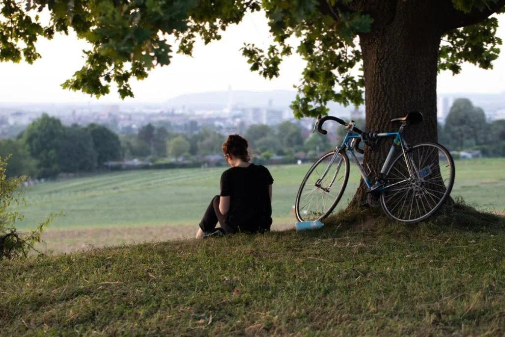 Jeune femme assise à côté d'un vélo vintage de course